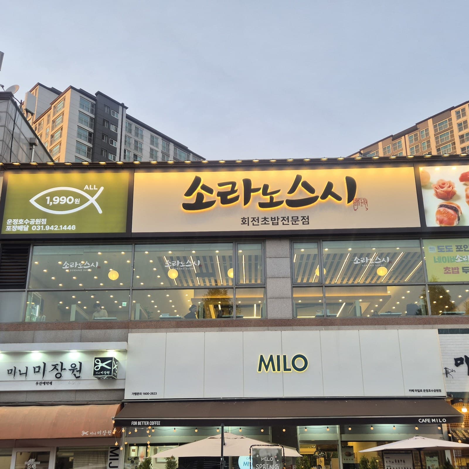 저녁 무렵 불이 켜진 소라노스시 운정호수공원점 외관과 대형 간판